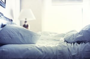 Blue themed bed sheets and pillows messed up after nights sleep.