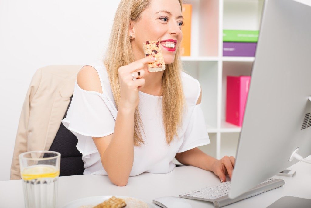 woman eating snacks at her desk