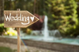 Wedding decor. Wooden plaque with the inscription Wedding. Wedding on a plate green background and a fountain. Wedding decorations,