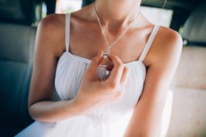 woman holding the pendant of her necklace