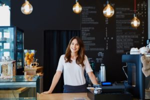 Cafe owner standing behind the cashier