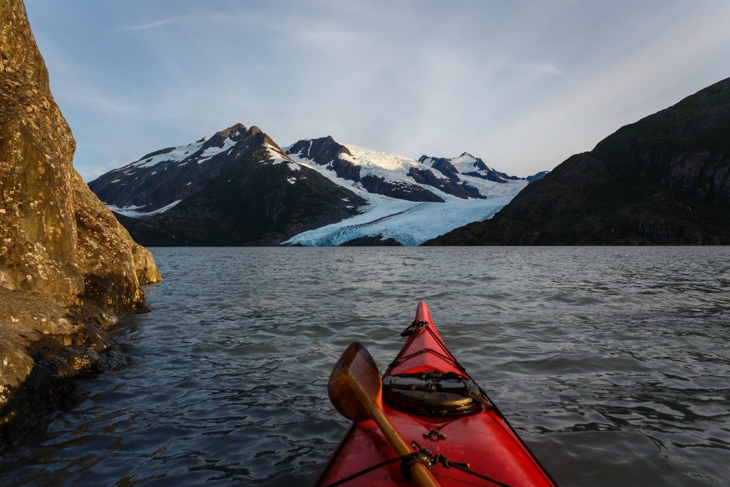 Kayaking to glacier in the Alaska wilderness on sunny summer day