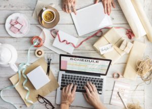 people's hands working on a laptop and creating invitations