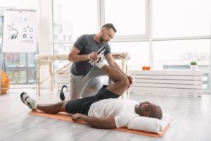 Trainer stretching athlete