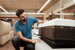 Man checking out a mattress