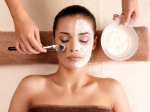 Young woman receiving facial mask