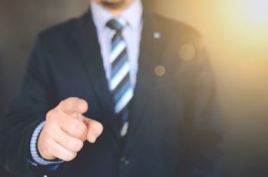 mean wearing suit pointing