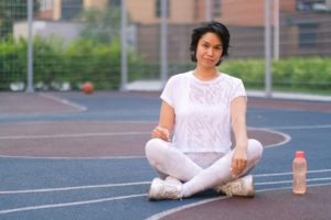 woman sitting with water bottle after exercise