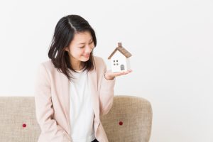 woman holding a model house