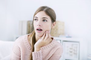 young woman touching her cheek