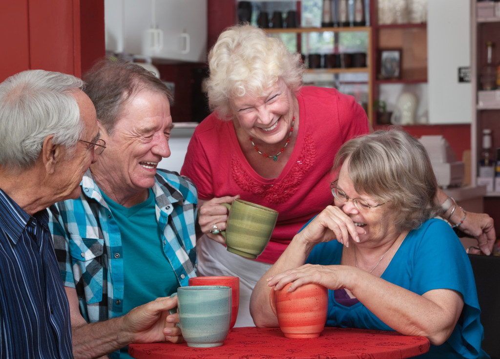 group of laughing seniors in coffee shop