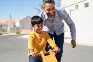 dad teaching son to ride a bike
