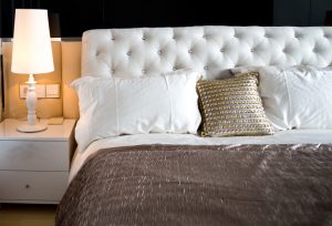 A large bed and bedside lamp in a bedroom