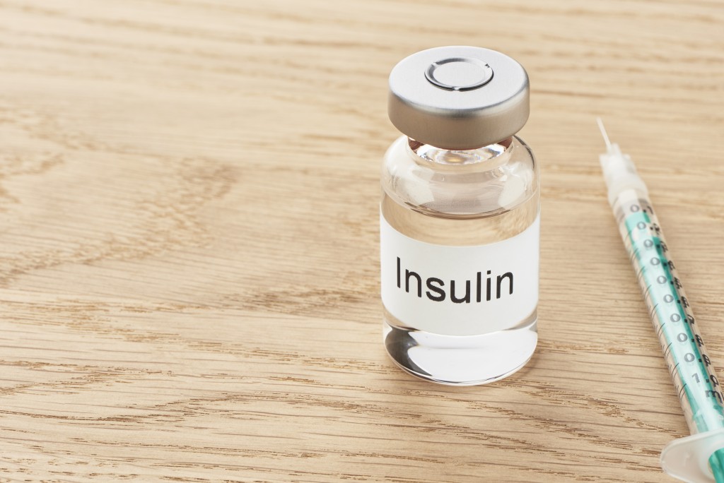 insulin and syringe on wooden table