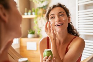 woman applying cream on her face