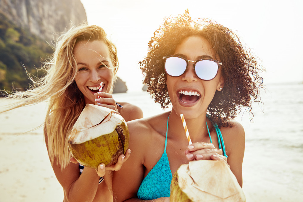 2 woman drinking and enjoying coconut water